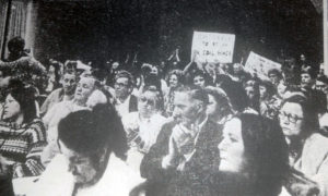 Black and white photo of people marching at a protest