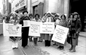 Women holding protest signs at a protest in the 70s
