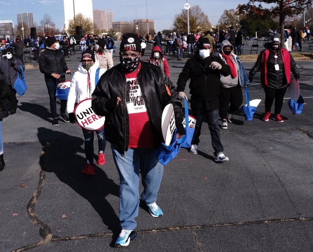 Person in a mask stops to pose at a rallyt