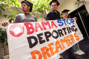 People holding a banner that says Obama Stop Deporting Dreamers