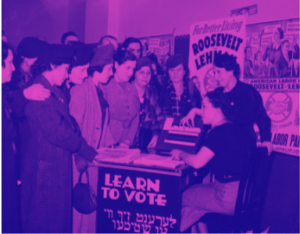 Women in 1930s style coats and hats gather around a table that has a sign on the side reading "Learn to Vote" in Englisn and Yiddish. A campaign poster for FDR hangs on the wall.