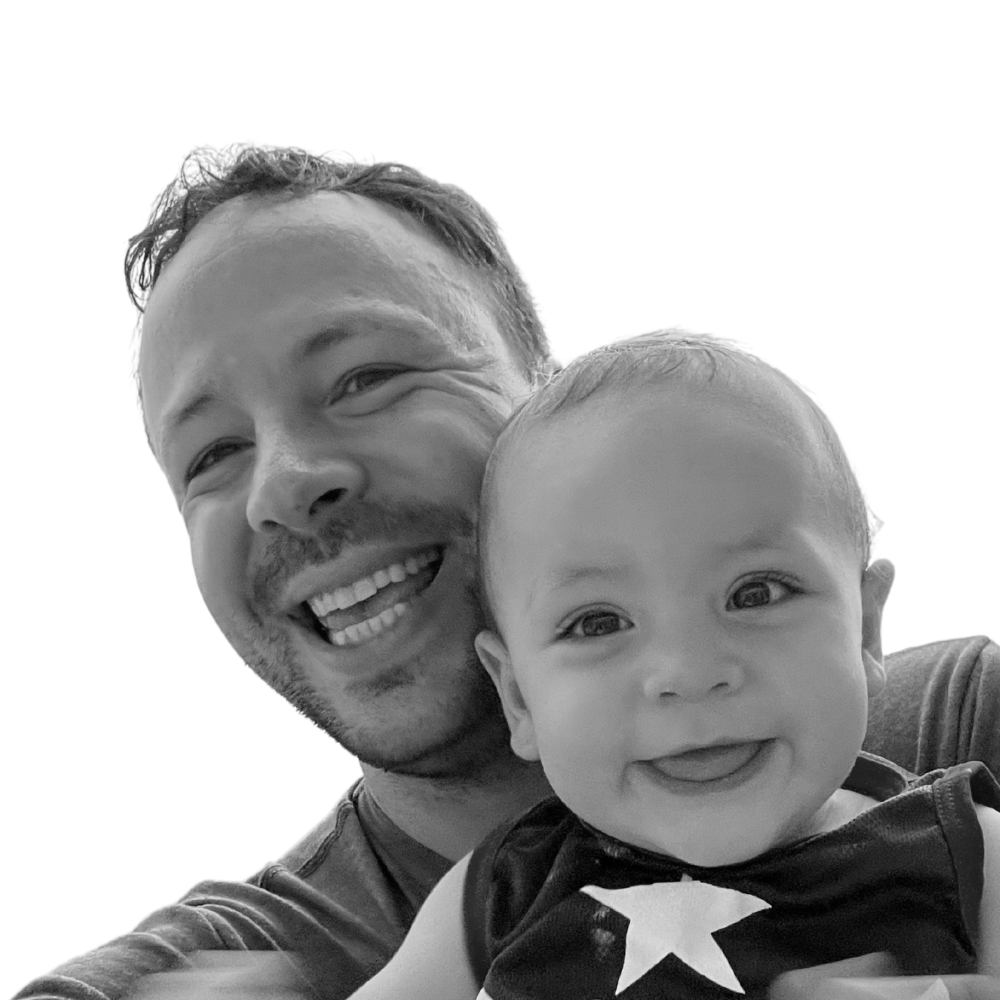 Black and White photo of Matt and his baby smiling