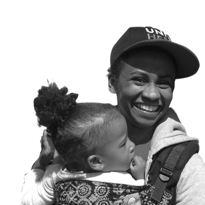 Black and white photo of Stephanie Greenlea smiling and holder her child in her arms